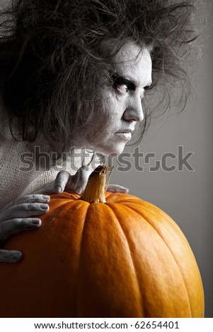 Woman with a bleached face and pumpkin. Halloween theme.