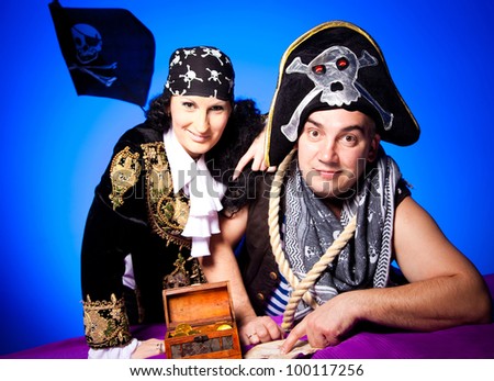 actors in a suits of the pirates near the map and treasures  on a blue background