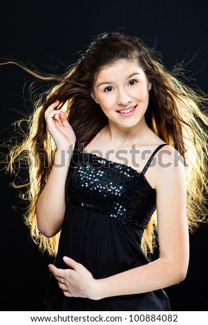 cute  teenager girl with  beautiful healthy long dark hair  on black  background
