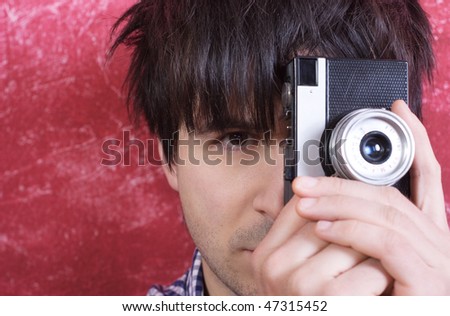 Portrait of handsome man photographer holding vintage film camera
