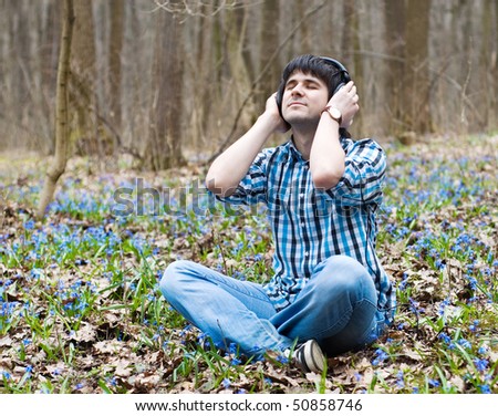 Man in headphones meditate in spring wood