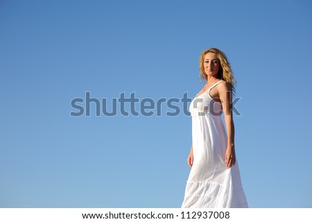 beauty woman in white dress walking against blue sky