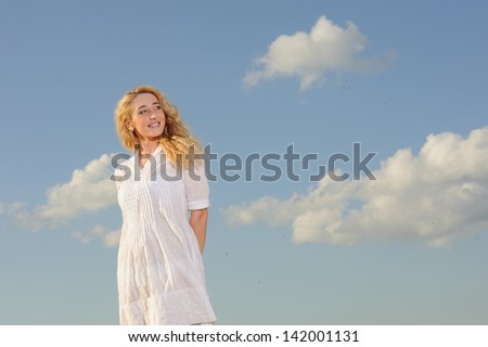portrait of beauty woman in white dress against the blue sky