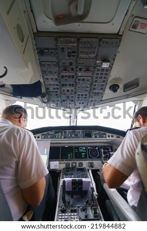 GENEVA - SEPTEMBER 11: Etihad Regional pilots in aircraft cockpit on September 11, 2014 in Geneva, Switzerland. Darwin Airline, operating under the brand name Etihad Regional since January 2014