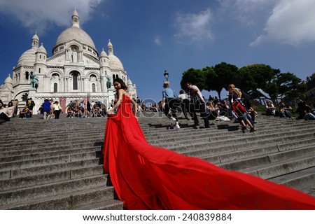 PARIS - SEP 10: model posing in red dress for photographer near Basilica of the Sacred Heart  on September 10, 2014 in Paris, France. Paris, aka City of Love, is a popular travel destination.