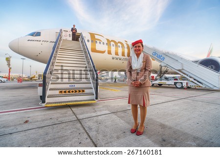 DUBAI, UAE - MARCH 31, 2015: Emirates crew member near Boeing-777. Emirates is one of two flag carriers of the United Arab Emirates along with Etihad Airways and is based in Dubai.