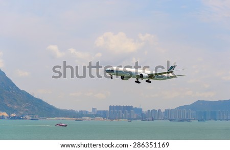 HONG KONG - JUNE 04, 2015: Cathay Pacific aircraft landing. Cathay Pacific is the flag carrier airline of Hong Kong, with its head office and main hub located at Hong Kong International Airport