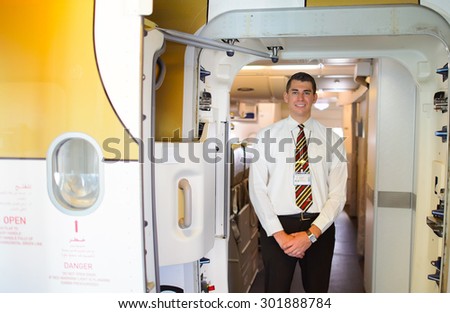 MOSCOW - DECEMBER 10, 2014: handsome Emirates crew member meet passengers. Emirates handles major part of passenger traffic and aircraft movements at the airport.