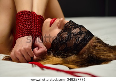 Young bounded woman on the bed