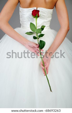 stock photo back of young woman in white wedding dress hold red rose
