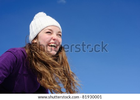 Laughing woman isolated on blue sky