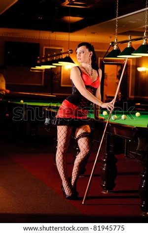 Sexy woman posing near the billiard table