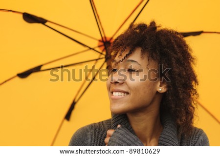Close up portrait of pretty African American girl with yellow umbrella