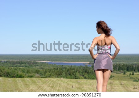 Calm slim woman stand on the green field