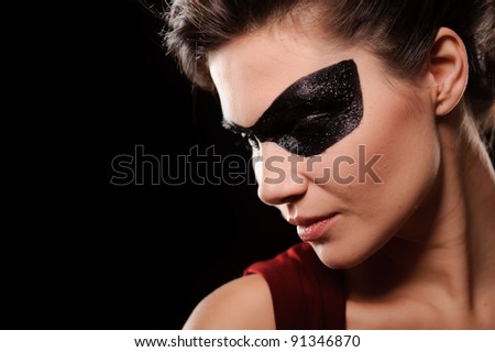 Portrait of sexy woman with black party mask on face, isolated on black