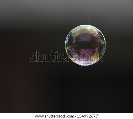 A Single Bubble Floating Over A Dark Background