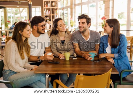A group of friends talking and drinking coffee at the cafe