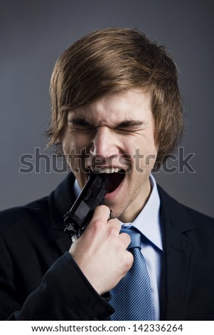 Stressed businessman with a gun on his mouth