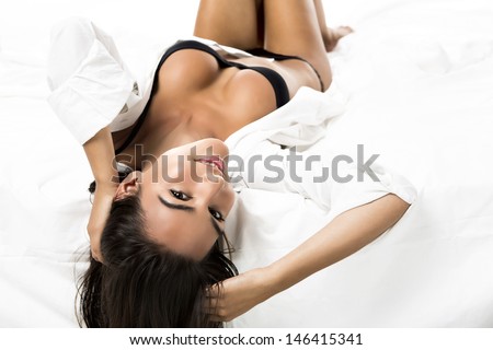 Beautiful And Sexy Woman Lying On The Bed And Smiling, Isolated On White Background
