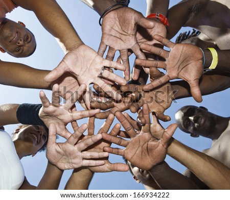 A group of mixed race people putting hands together