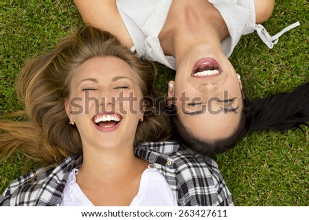 Female best Friends lying on the grass and laughing