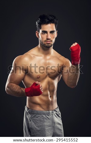 Portrait of a young male Body Combat atlhlete, isolated over a dark background