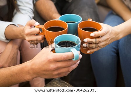 Group of friends making a toast with coffee