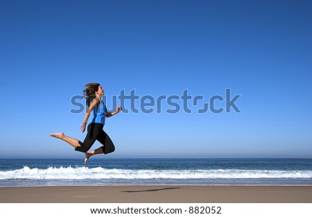 Young active woman alone in the beach doing some morning sports, running and jumping in the beach.