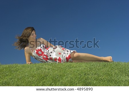 Beautiful woman relaxing on a beautiful green field
