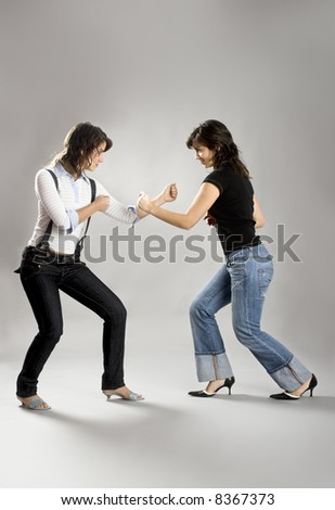 Two young beautiful sisters having fun simulating a fight  - This models are true twins
