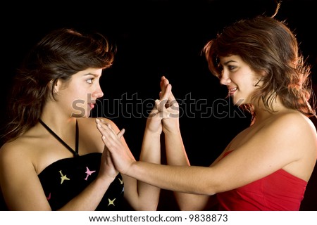 Two young beautiful sisters giving the hands and having fun - This models are true twins
