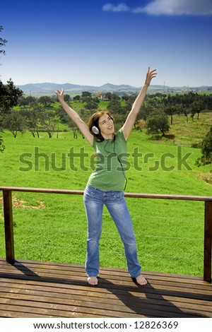 Woman dancing and listen music on a spring environment
