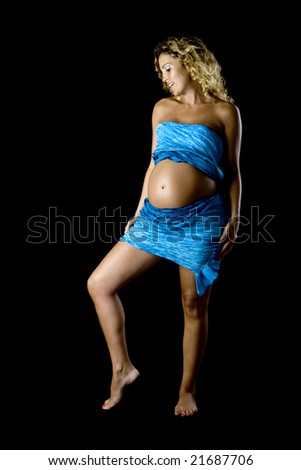 Beautiful pregnant woman posing with a blue handkerchief isolated on a black background