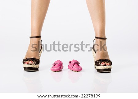 Picture of a young attractive woman with a baby shoes under her legs