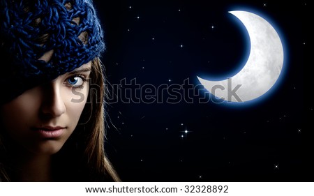 Portrait of a beautiful and young woman at night with a artificial moon on the background