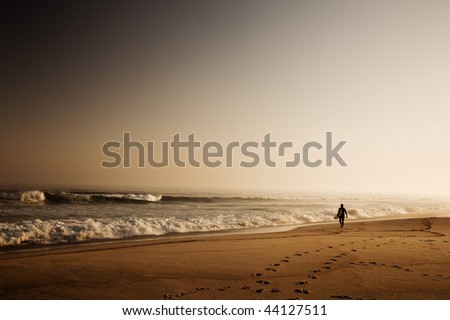 Beautiful beach with a surfer going to the waves early by the morning