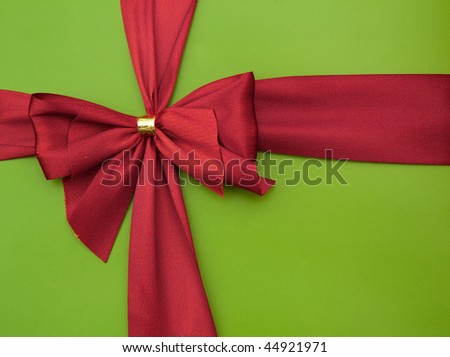 Bow of red satin ribbon on a green background