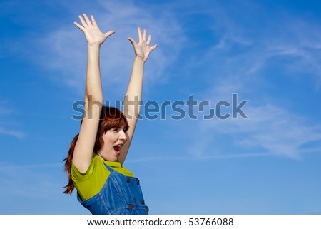 Portrait of a beautiful woman over a blue sky with arms open