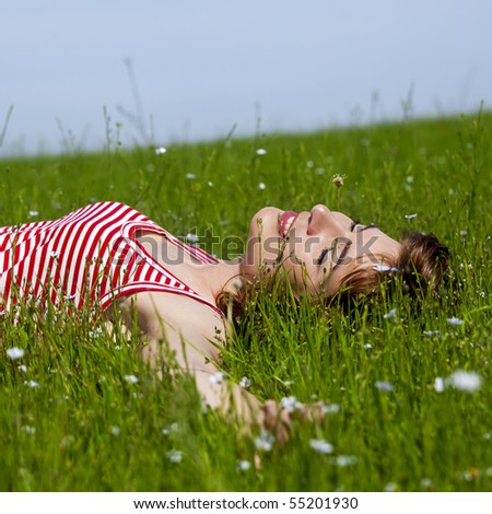 Young woman relaxing on a beautiful green meadow