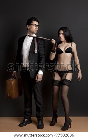 Sexy young woman grab the tie of the business man. Concept about work and pleasure