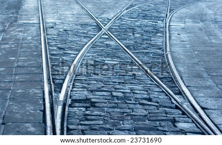 A closeup of a tram rail switch with city pavement