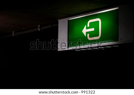 A green emergency light as can be found in any underground parking place.