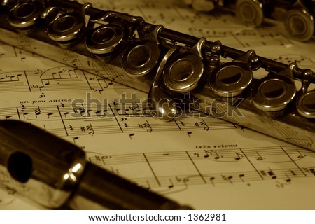 A detail of a flute resting on a sheet of music score