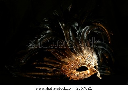 stock photo : A luxurious golden mask with long feathers on a black background
