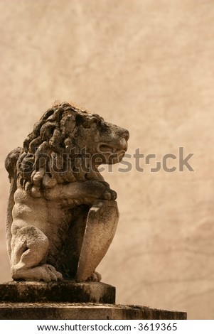 Statue of a weathered stone lion holding a shield