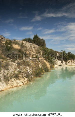 A small turquoise pool filled by a hot thermal spring in Bagno Vignoni, Tuscany
