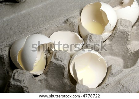 broken egg shells in a cardboard egg crate