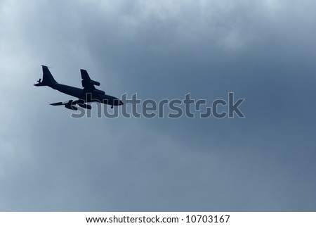 a plane silhouette against dark clouds