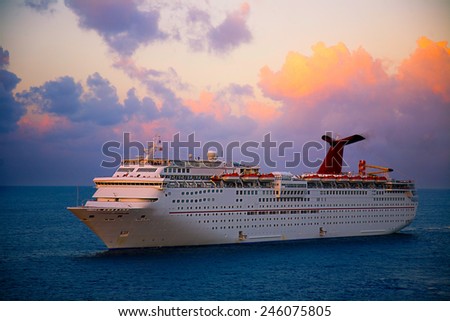 GEORGETOWN, GRAND CAYMAN - MARCH 25, 2009:  Georgetown is a popular for cruise lines in the Caribbean.  This ship is anchored off shore at sunset.