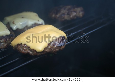Cheeseburger on the grill with smokey background